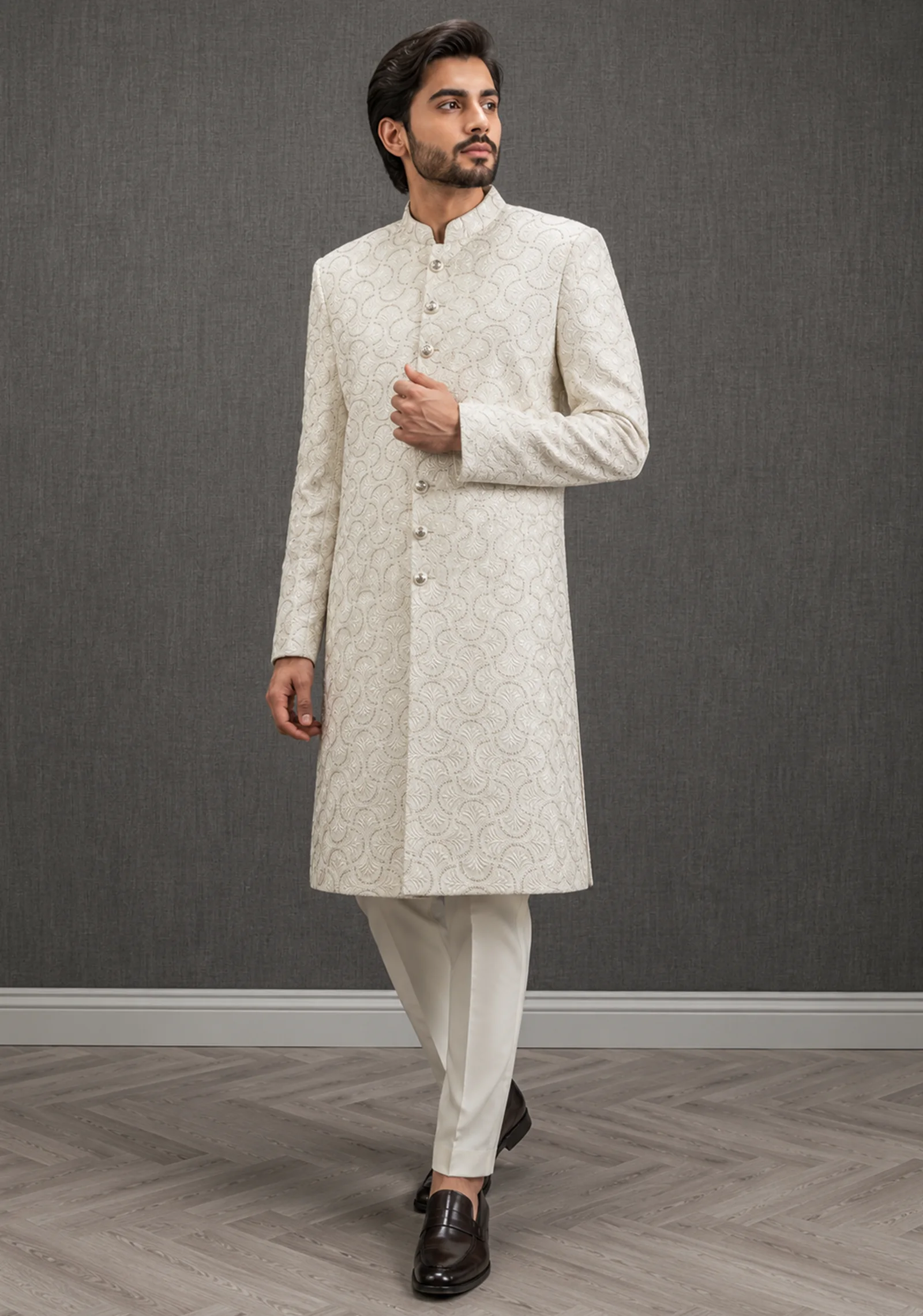 A gentleman wearing the "Ivory Regal Heritage" premium sherwani, showcasing sharp tailoring and refined hand-made Zari work surface ornamentation as seen in 50.webp, 51.jpg, 52.webp, and 53.jpg.