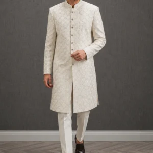 A gentleman wearing the "Ivory Regal Heritage" premium sherwani, showcasing sharp tailoring and refined hand-made Zari work surface ornamentation as seen in 50.webp, 51.jpg, 52.webp, and 53.jpg.