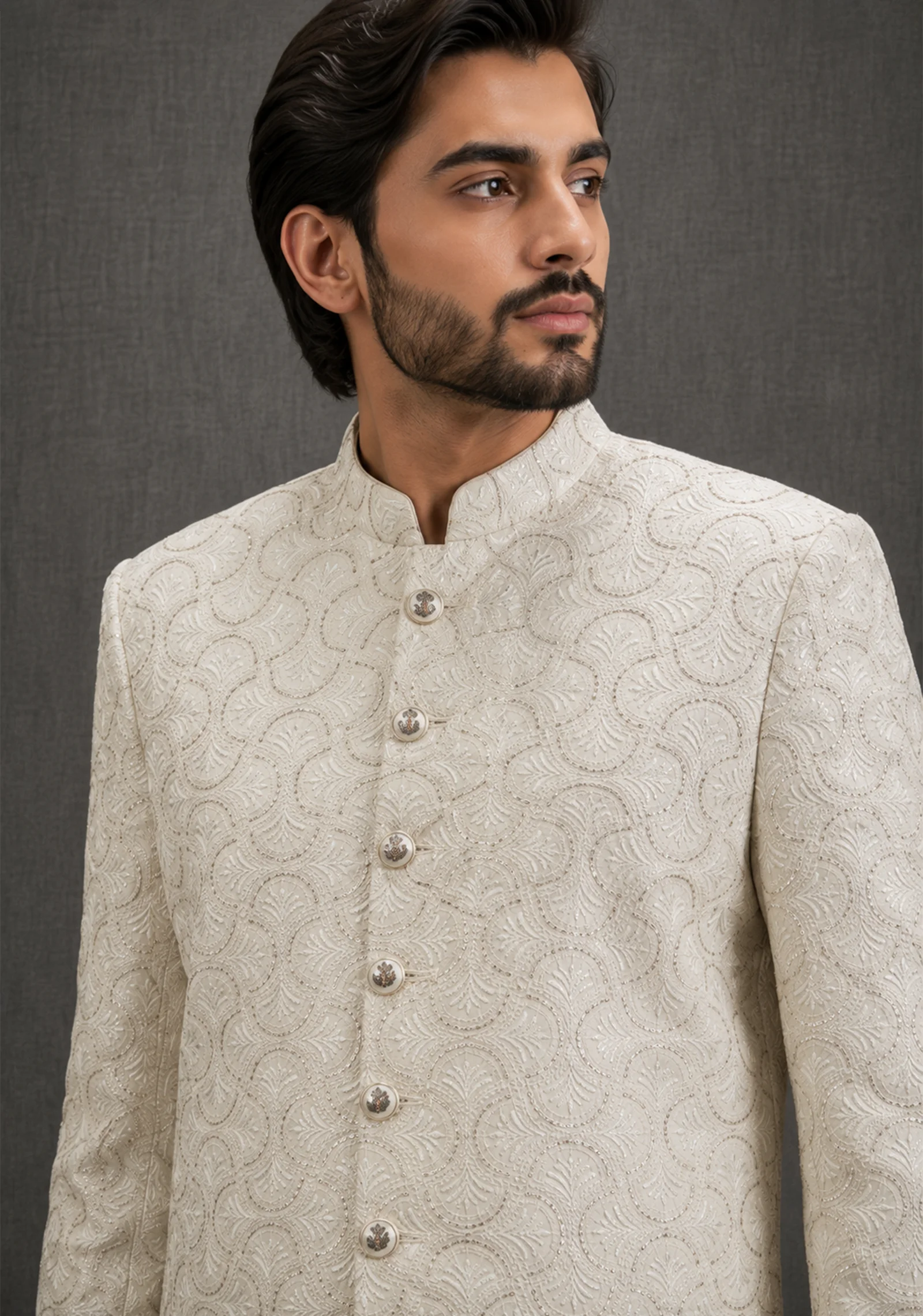 A gentleman wearing the "Ivory Regal Heritage" premium sherwani, showcasing sharp tailoring and refined hand-made Zari work surface ornamentation as seen in 50.webp, 51.jpg, 52.webp, and 53.jpg.