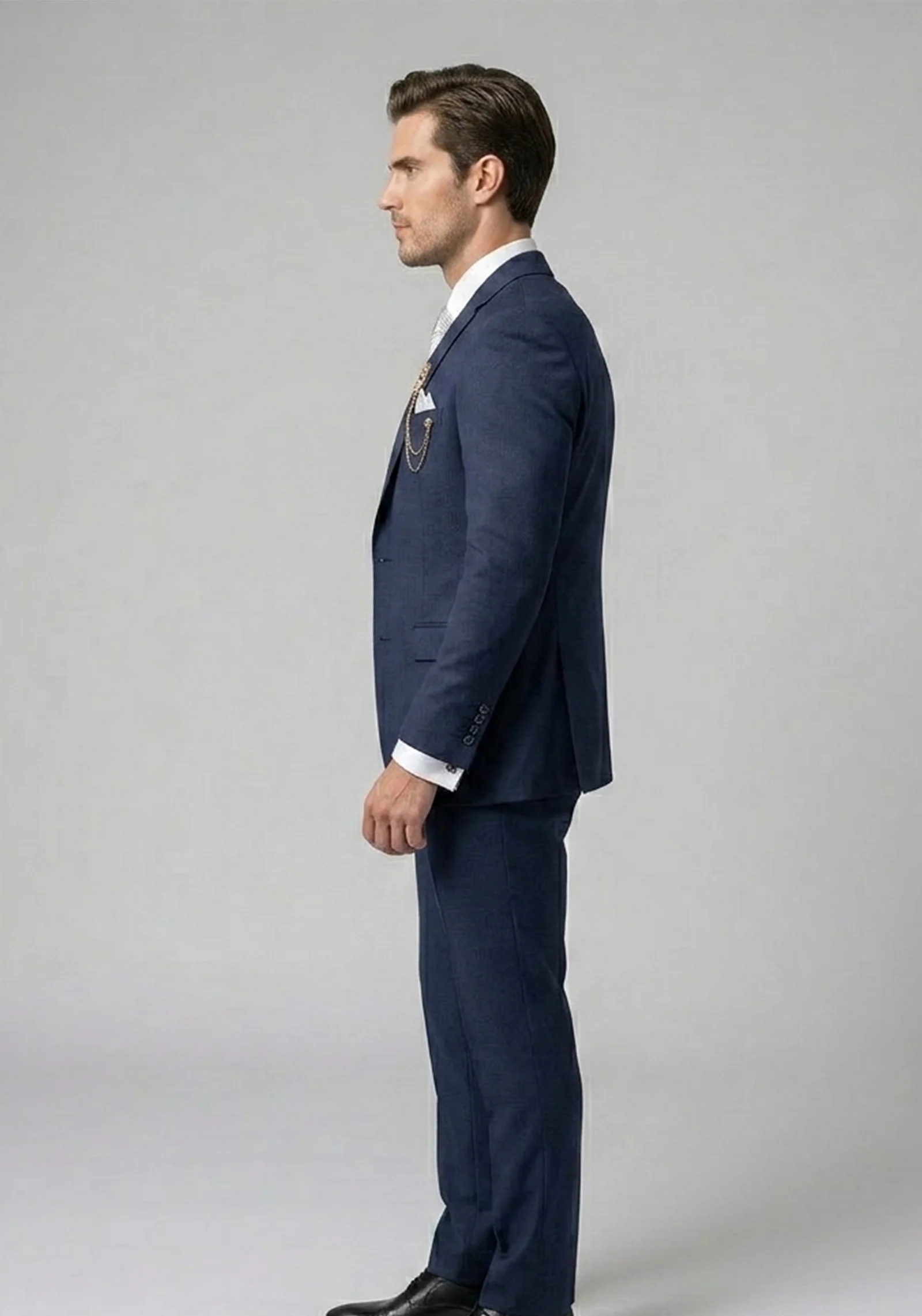 Model wearing the "Royal Crest" Navy Blue premium three-piece formal suit with signature brooch detail.