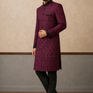 A gentleman wearing the "Royal Crimson Heritage" premium sherwani, showcasing sharp tailoring and refined hand-made Zari work surface ornamentation as seen in 10_2.jpg, 11_2.webp, 12_2.webp, and 13_2.jpg.