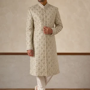 A gentleman wearing the "Ivory Regal Heritage" premium sherwani, showcasing sharp tailoring and refined Zari work surface ornamentation as seen in 15.webp, 16.webp, 17.jpg, and 18.jpg.