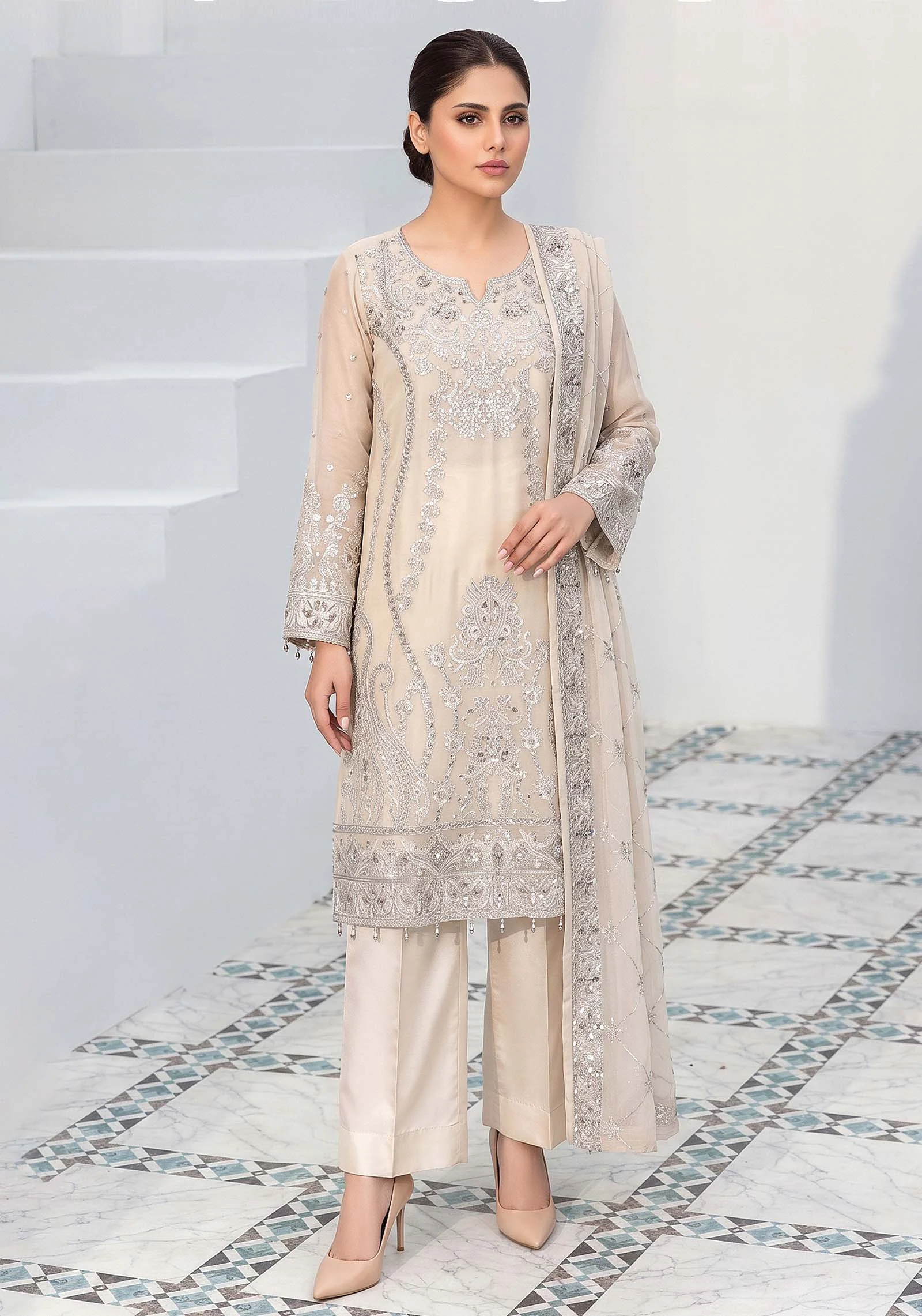 Woman wearing a Pearl Cream A-Line Crinkle suit with silver Tilla work and Tussles