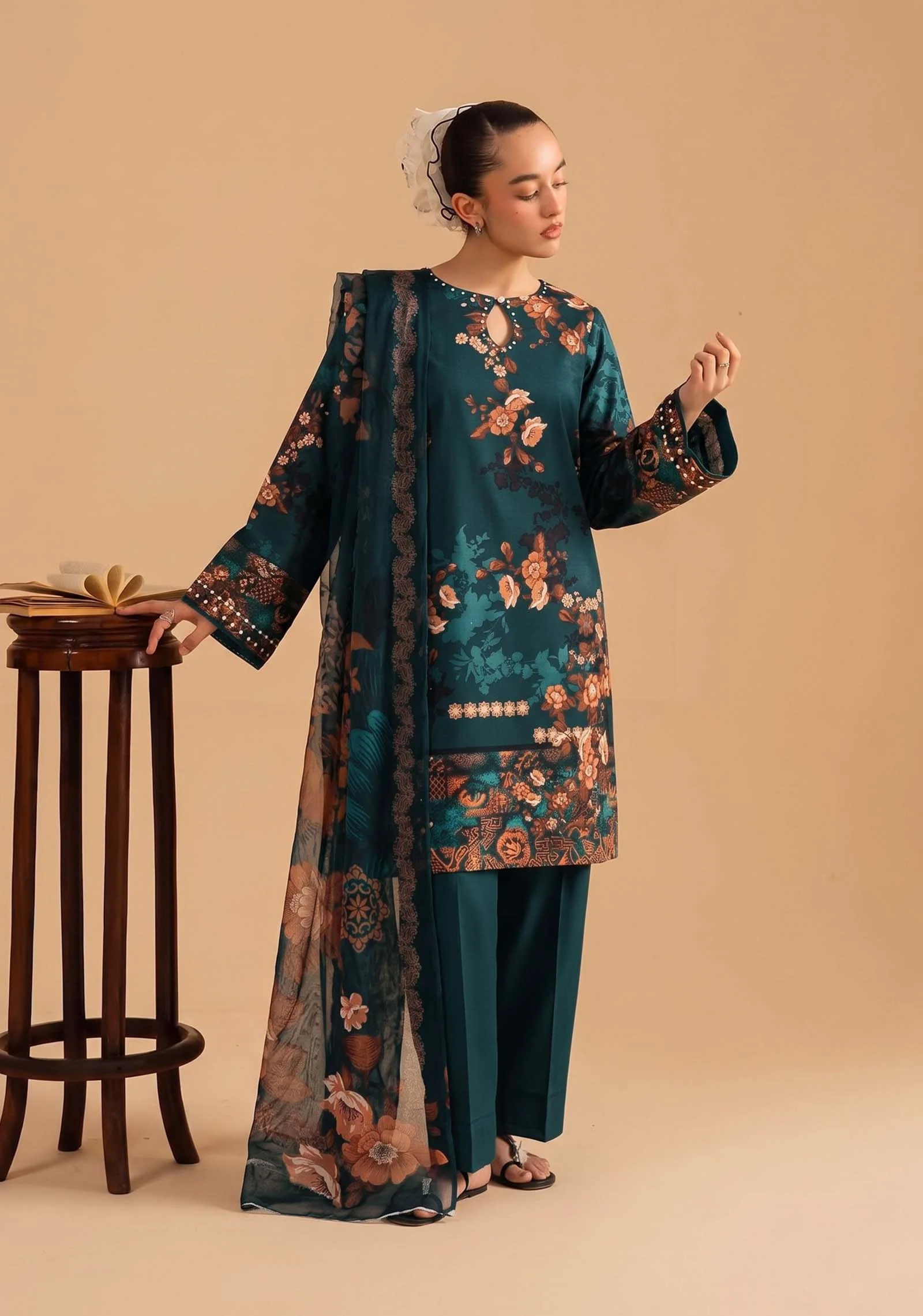 Model wearing a teal 3 piece suit with floral motifs from AL Hassan Lehnga House :
